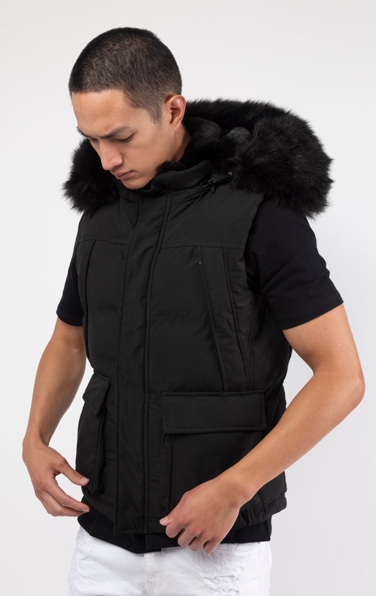 Black Faux fur-lined hooded jacket made of a water-resistant polyester shell featuring a removable hood with a removable faux fox fur trim. The hood and front of the jacket are lined with faux rabbit fur for superior warmth. The jacket has JC branded zippers throughout, dual pockets at the sides with button openings, and a full zipper front opening. Faux suede taping adorns the front zipper.